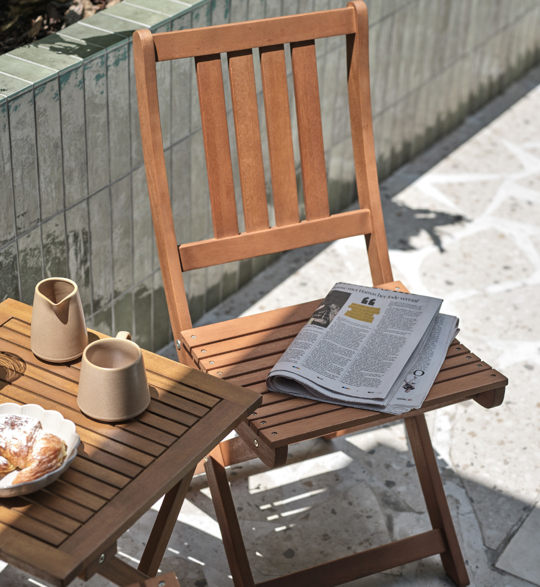 Table et chaise pliantes de jardin sur terrasse avec tasse à café